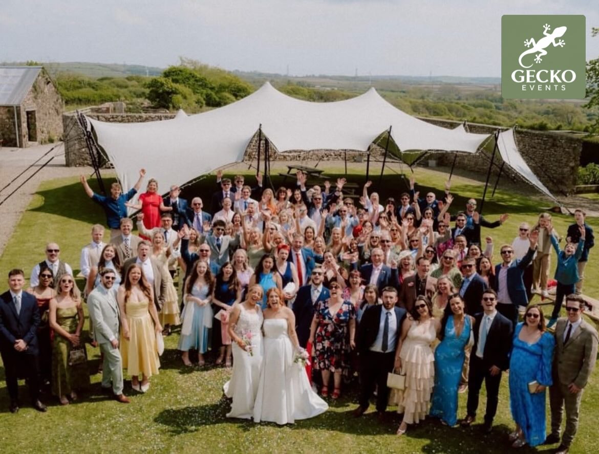 Wedding party gathered beneath a Gecko Events stretch tent