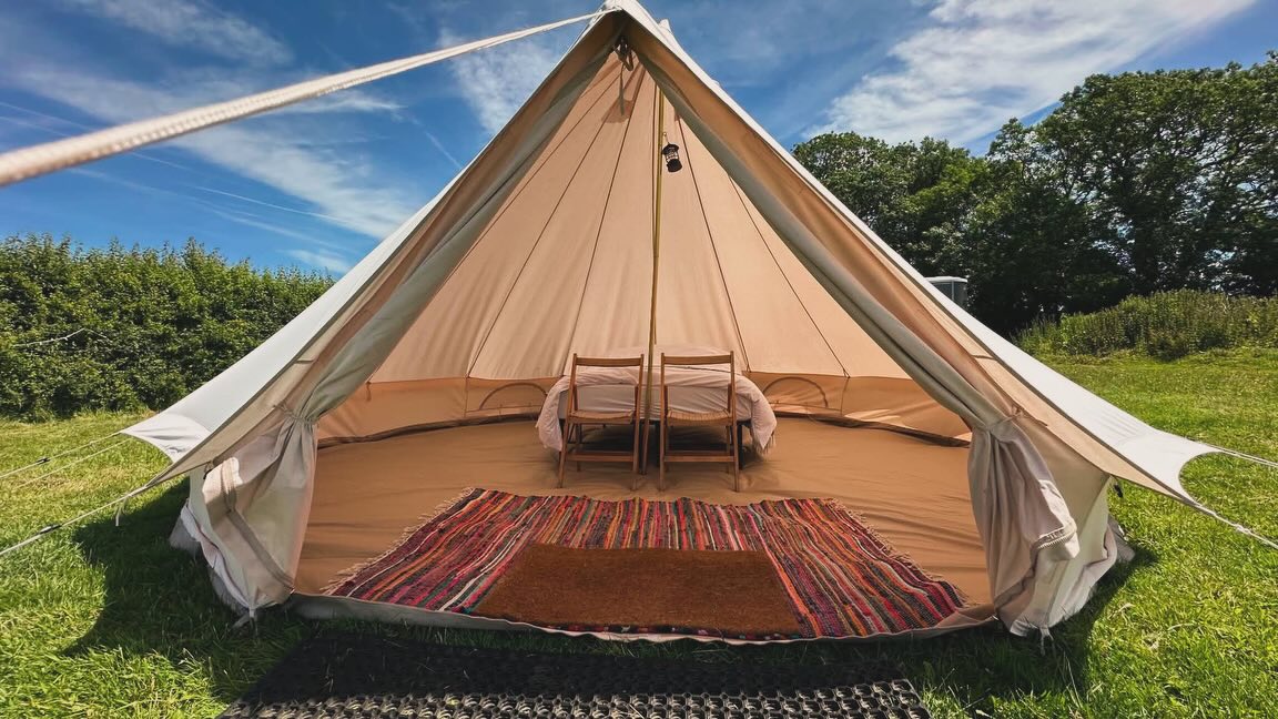 Open bell tent with rugs and seating
